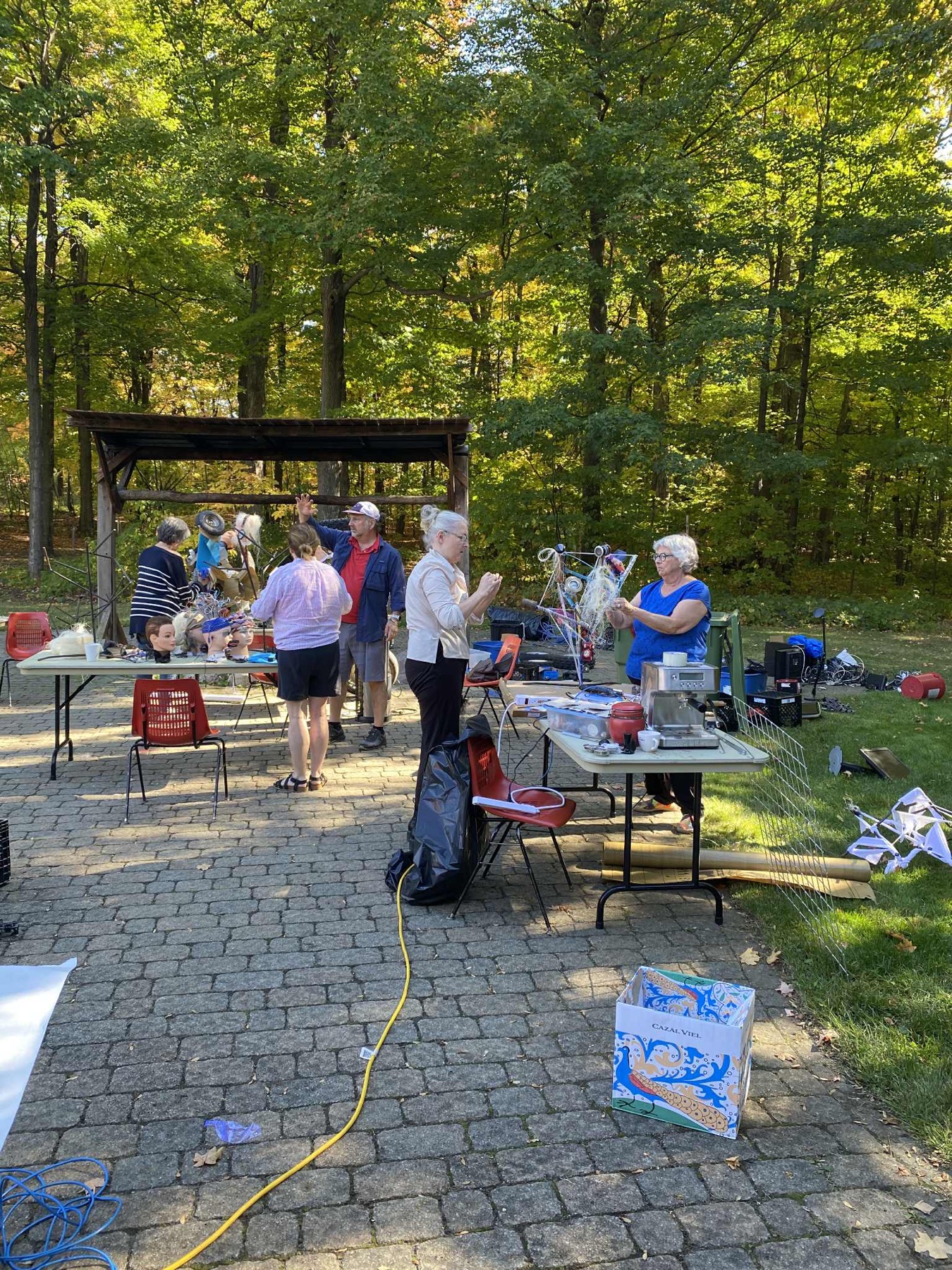 Des artistes réunis en plein air autour de matériaux et de formes en construction.